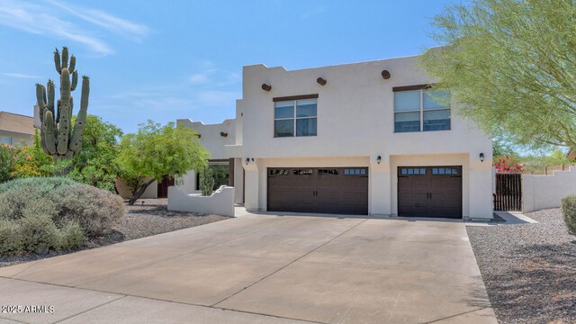 3611 E Ahwatukee Dr, Phoenix, AZ 85044 - pueblo-style home featuring a garage, concrete driveway, stucco siding, and a gate