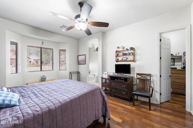 bedroom featuring arched walkways, visible vents, ensuite bathroom, ceiling fan, and wood finished floors