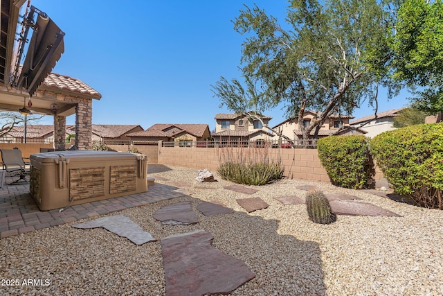 view of yard featuring a patio area, a fenced backyard, a residential view, and a hot tub