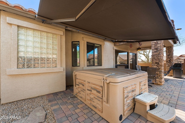 view of patio with fence and a hot tub