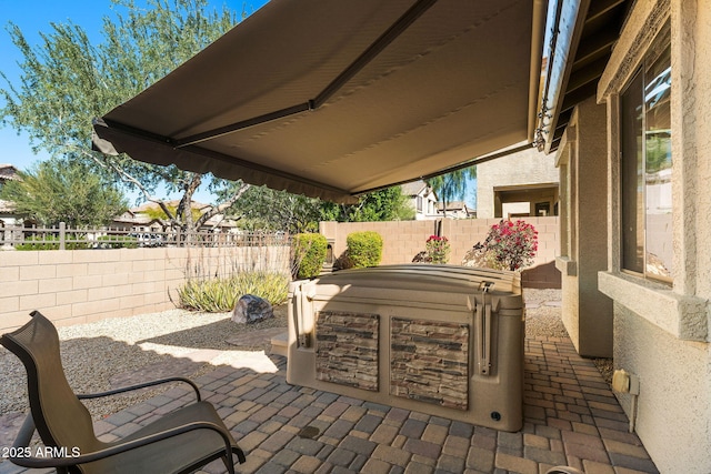 view of patio / terrace with a fenced backyard and a hot tub