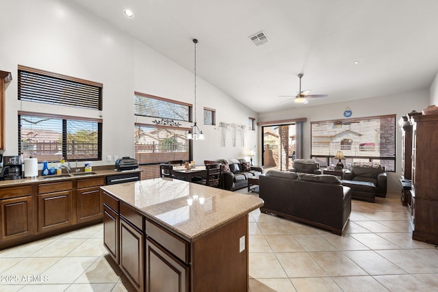 kitchen featuring open floor plan, light tile patterned flooring, visible vents, and a center island