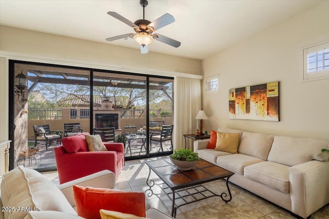 living area with a ceiling fan, tile patterned flooring, and plenty of natural light