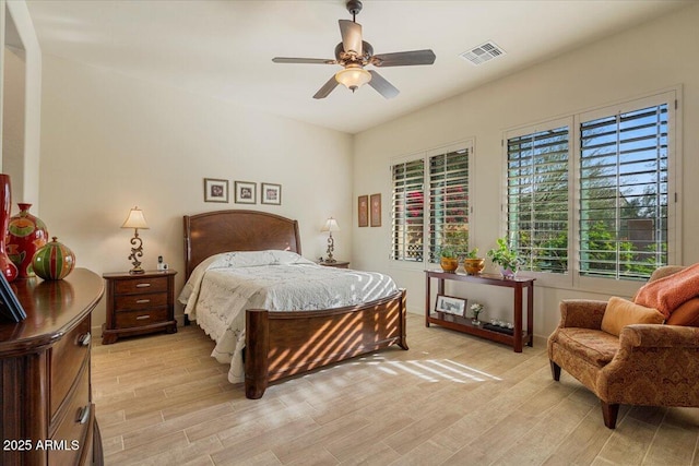 bedroom with light wood-type flooring, ceiling fan, and visible vents