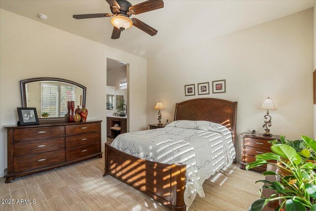 bedroom with light wood-style floors, ceiling fan, and ensuite bathroom