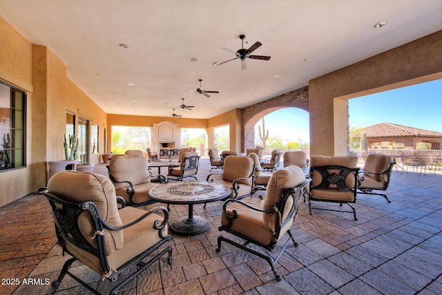 view of patio / terrace with a fireplace and a ceiling fan