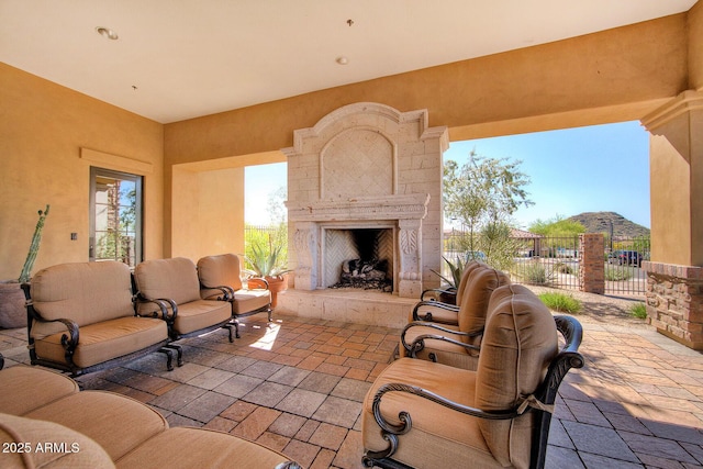 view of patio / terrace with an outdoor living space with a fireplace and fence