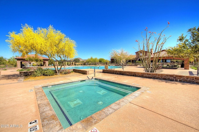 pool with a gazebo, a patio area, and a hot tub