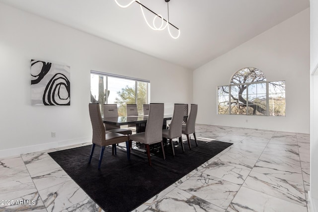 dining space with high vaulted ceiling