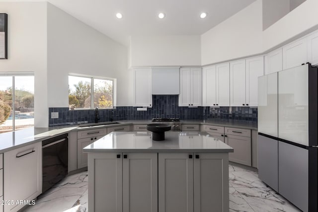 kitchen with sink, dishwasher, fridge, a center island, and decorative backsplash