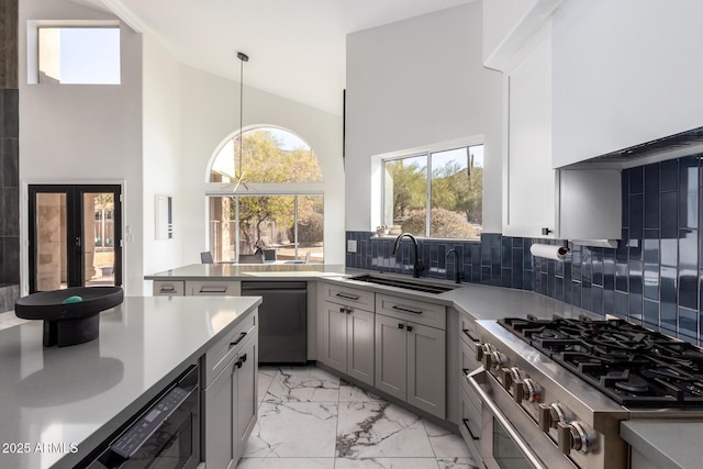 kitchen featuring pendant lighting, dishwasher, sink, gray cabinetry, and high end range