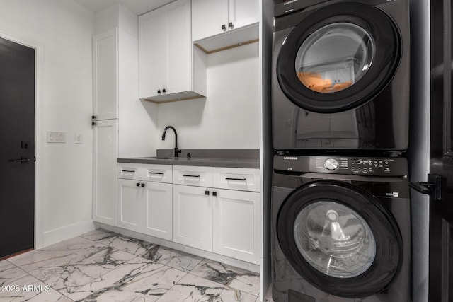 laundry area featuring cabinets, sink, and stacked washer and clothes dryer