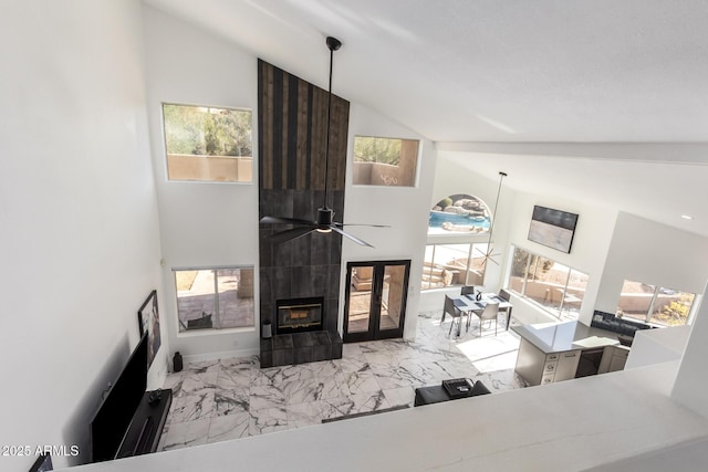 living room with a tiled fireplace and vaulted ceiling