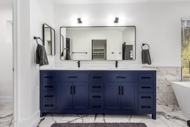 bathroom with vanity, tile walls, and a bathtub