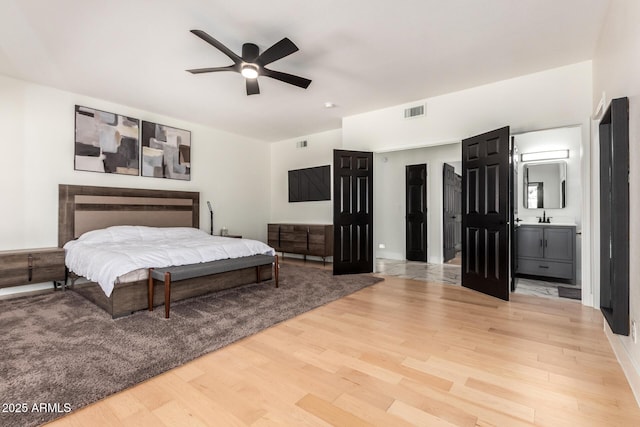 bedroom with sink, ceiling fan, and light wood-type flooring