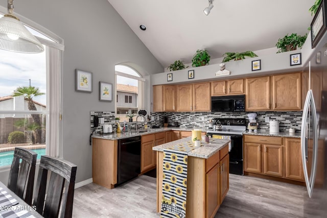 7460 E Kiowa Ave, Mesa, AZ 85209 - kitchen with black appliances, decorative backsplash, a sink, light wood-style floors, and light stone counters