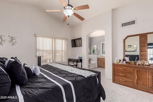 7460 E Kiowa Ave, Mesa, AZ 85209 - carpeted bedroom with arched walkways, multiple windows, ensuite bath, lofted ceiling, and ceiling fan