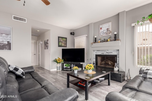 7460 E Kiowa Ave, Mesa, AZ 85209 - living room featuring wood finished floors, a ceiling fan, plenty of natural light, and a fireplace