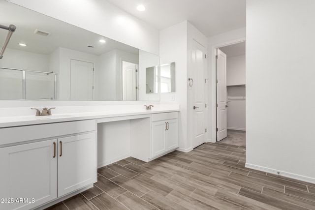 bathroom with vanity and a shower with shower door