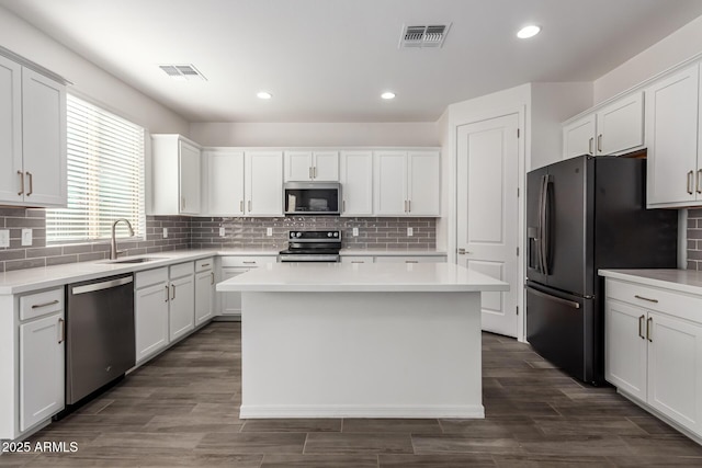 kitchen featuring white cabinetry, a center island, appliances with stainless steel finishes, and sink