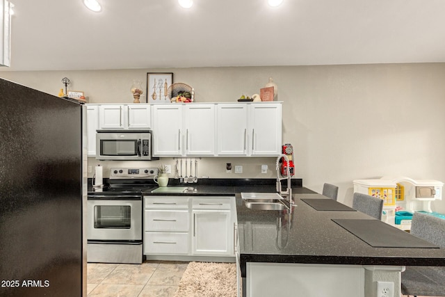 kitchen with a sink, stainless steel appliances, a peninsula, and white cabinets