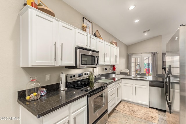 kitchen featuring visible vents, lofted ceiling, appliances with stainless steel finishes, and white cabinets