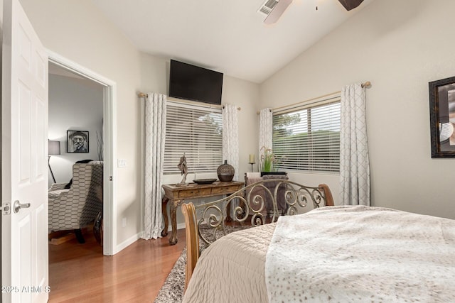 bedroom featuring wood finished floors, visible vents, baseboards, lofted ceiling, and ceiling fan