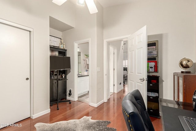 office space featuring a ceiling fan, wood finished floors, and baseboards