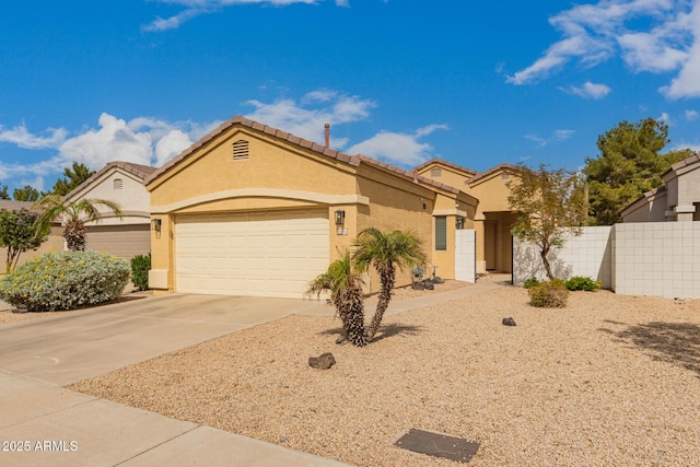 mediterranean / spanish home with fence, a tile roof, stucco siding, a garage, and driveway