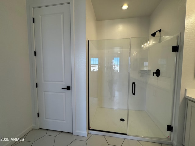 bathroom with a shower with door and tile patterned flooring