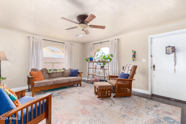 living room featuring wood-type flooring, plenty of natural light, and ceiling fan