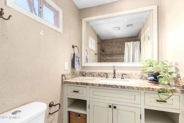 bathroom featuring vanity, toilet, and walk in shower