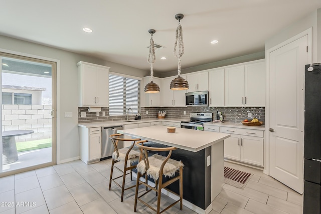 9352 E Saturn Ave, Mesa, AZ 85212 - kitchen with stainless steel appliances, a sink, light countertops, decorative backsplash, and recessed lighting