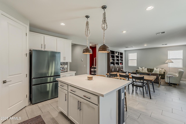 9352 E Saturn Ave, Mesa, AZ 85212 - kitchen featuring freestanding refrigerator, healthy amount of natural light, a kitchen island, decorative light fixtures, and recessed lighting