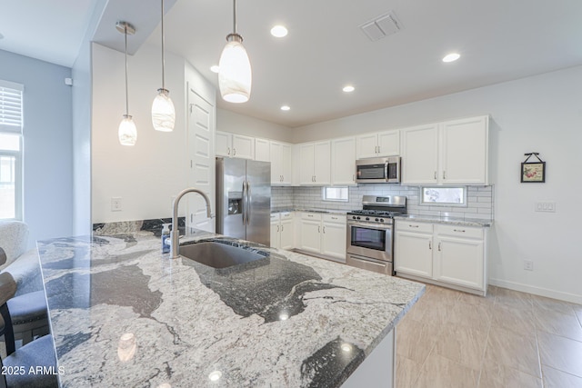 2929 E Mohave Ln, Apache Junction, AZ 85119 - kitchen featuring stainless steel appliances, a peninsula, light stone counters, white cabinetry, and backsplash