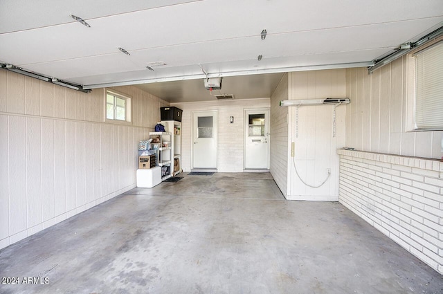 garage with wood walls and a garage door opener