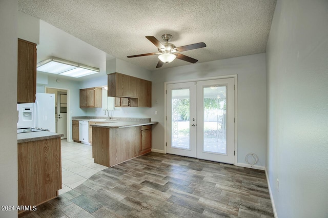 kitchen featuring kitchen peninsula, french doors, a textured ceiling, white appliances, and ceiling fan