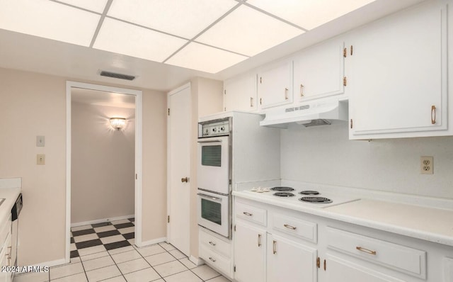 kitchen with white cabinetry, light tile patterned floors, white appliances, and a drop ceiling