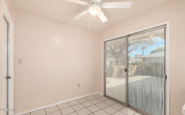 doorway featuring a textured ceiling, light tile patterned floors, and ceiling fan