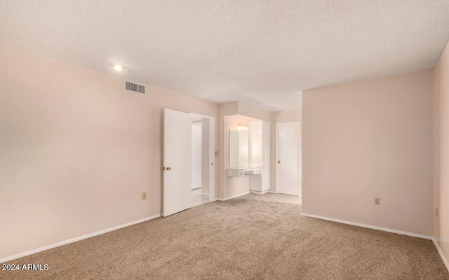 carpeted spare room with a textured ceiling