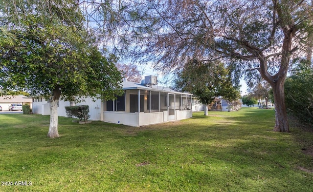 view of yard with a sunroom and central AC