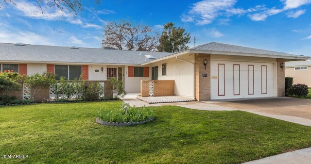 ranch-style home with a garage and a front lawn