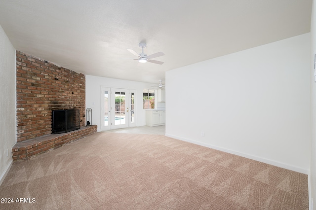 unfurnished living room with ceiling fan, light carpet, and a brick fireplace