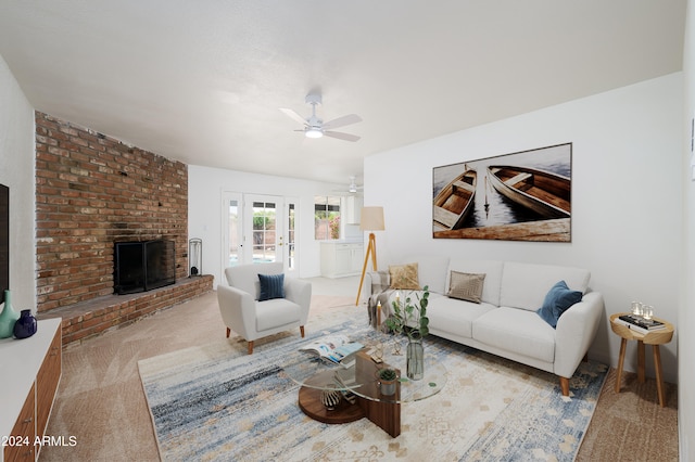 carpeted living room featuring ceiling fan and a fireplace