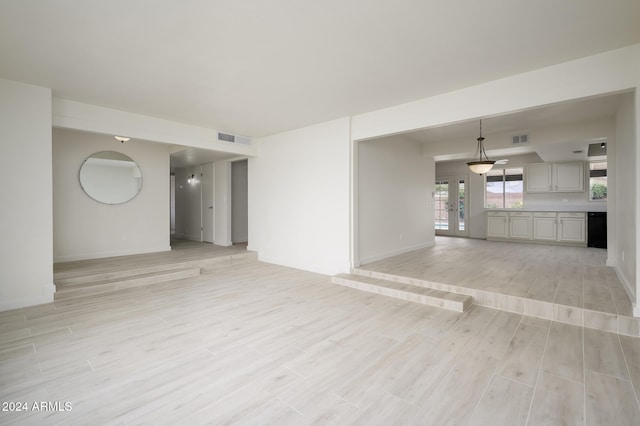 unfurnished room featuring french doors and light hardwood / wood-style flooring