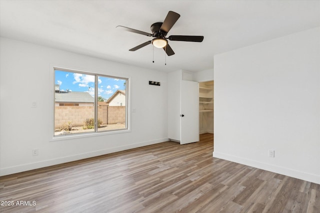 4829 E Apache Cir, Phoenix, AZ 85044 - unfurnished bedroom with wood finished floors, ceiling fan, and a walk in closet