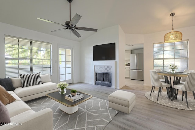 6885 E Cochise Rd Unit 219, Paradise Valley, AZ 85253 - living area featuring vaulted ceiling, light wood-type flooring, a ceiling fan, and a fireplace