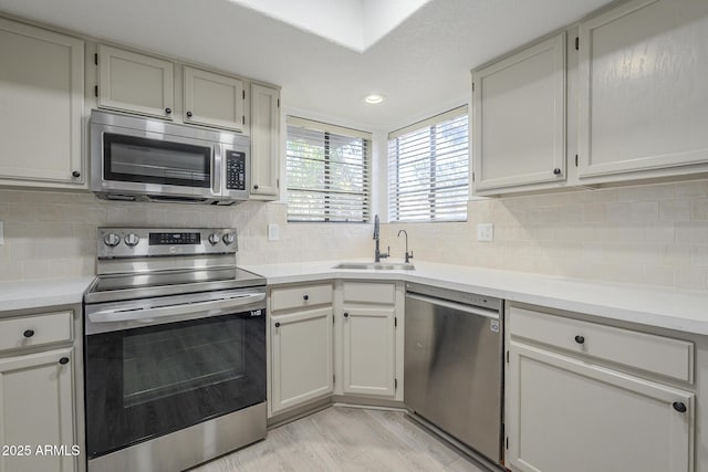 6885 E Cochise Rd Unit 219, Paradise Valley, AZ 85253 - kitchen featuring appliances with stainless steel finishes, light countertops, light wood-style floors, decorative backsplash, and recessed lighting