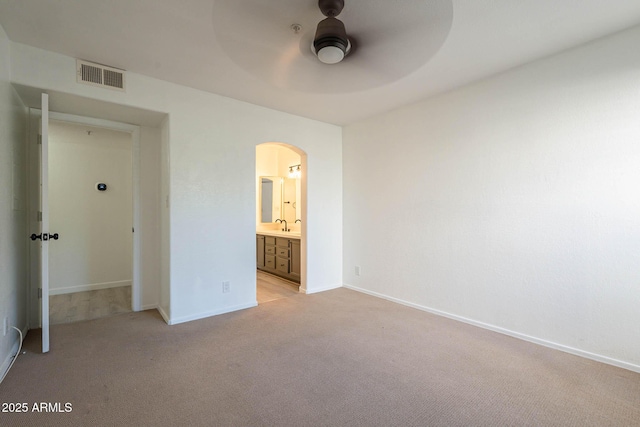 6885 E Cochise Rd Unit 219, Paradise Valley, AZ 85253 - unfurnished bedroom featuring arched walkways, light colored carpet, ensuite bathroom, and a ceiling fan