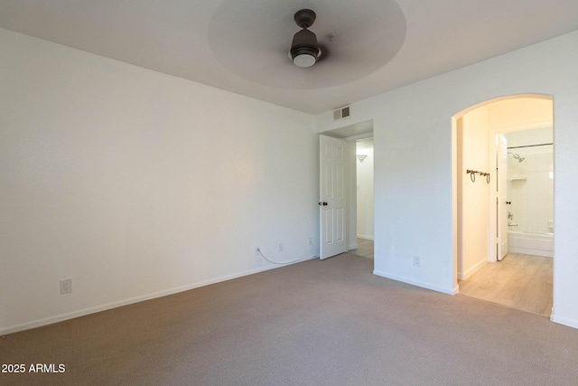 6885 E Cochise Rd Unit 219, Paradise Valley, AZ 85253 - unfurnished bedroom with arched walkways, carpet, connected bathroom, and ceiling fan
